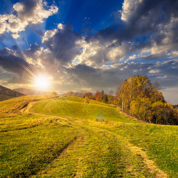 path on hillside meadow in mountain at sunset