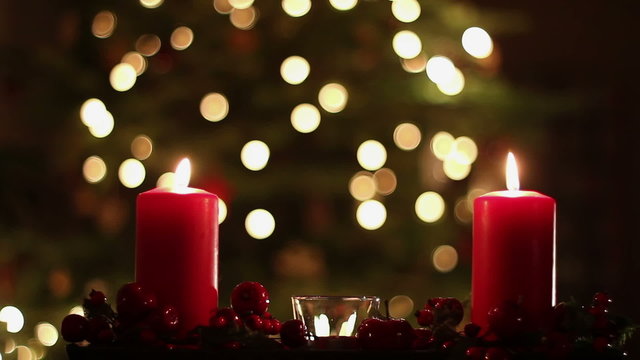 Two red candles with christmas atmospheric light in background