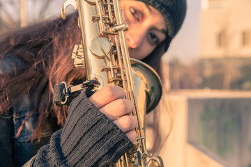 Beautiful young woman with her saxophone