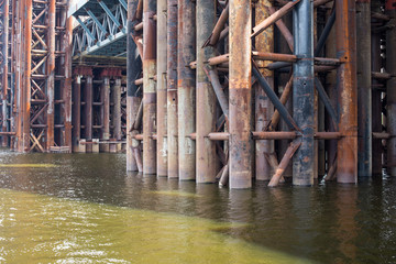 Bridge construction. Rusty metal piers.
