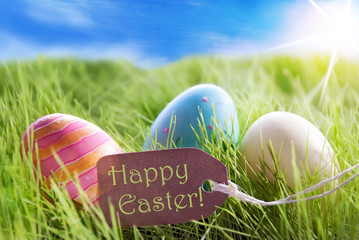 Easter Eggs On Sunny Green Grass With Label Happy Easter