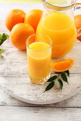 Glass of orange juice and oranges