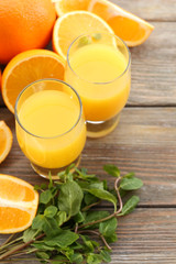 Glass of orange juice and slices on wooden table background