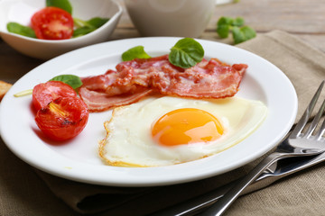 Bacon and eggs on rustic wooden planks background