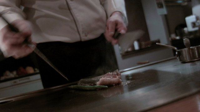 Chef steaming snapper fish fillet and vegetable Japanese Teppanyaki restaurant 