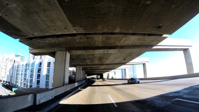 POV driving vehicle below elevated Highway built structure America