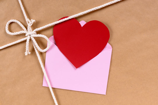 Brown paper package parcel background with red valentine heart shape card gift tag or love message photo