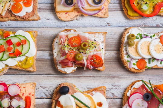 Sandwiches on wooden background, closeup, top view