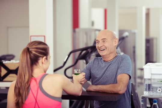älterer mann nimmt ein getränk im fitness-studio