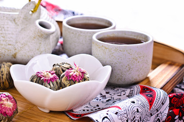 Green tea in the form of a ball with a red flower
