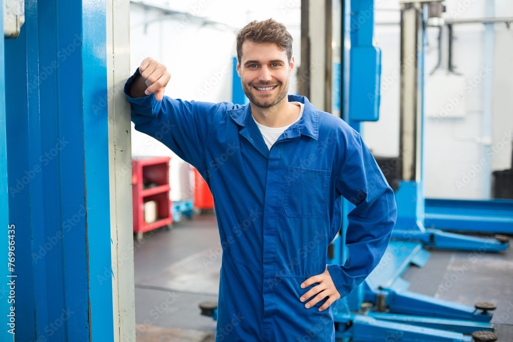 Poster smiling mechanic looking at camera