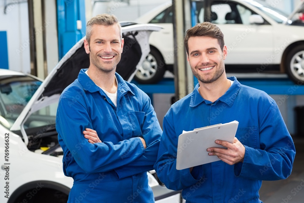 Poster team of mechanics smiling at camera