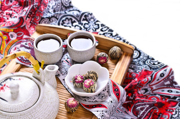Green tea in the form of a ball with a red flower