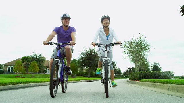 Healthy Young Ethnic Couple Cycling Together
