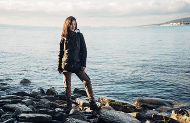 Woman standing on coastline near the sea