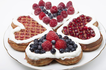 Waffle cookies in the form of hearts decorated with whipped crea