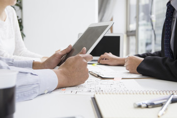 Men look at the floor plans in electronic tablet