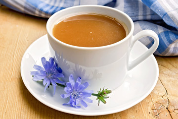 Chicory drink in white cup with flower on board