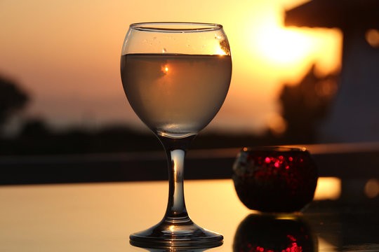 A glass of turkish rakia on a background of sunset