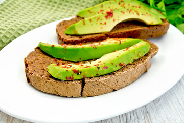 Sandwich with avocado and pepper on light board