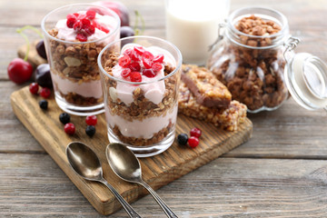 Healthy layered dessert with muesli and berries on table