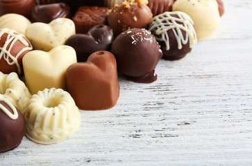 Delicious chocolate candies on wooden background