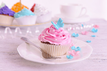 Delicious cupcakes on plate on table close-up