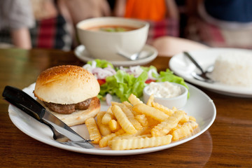 burger with French fries on the table in a cafe