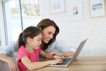 Mother and daughter playing on laptop computer