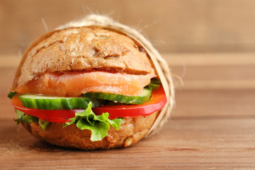 Sandwich with salmon on wooden background