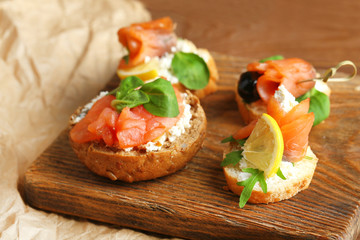 Sandwich with salmon on wooden background