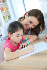 School girl with mother learning to write