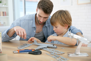 Father and son assembling airplane mock-up