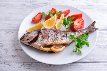 Tasty baked fish on table close-up