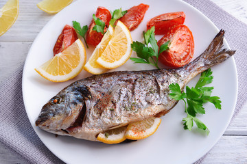 Tasty baked fish on table close-up