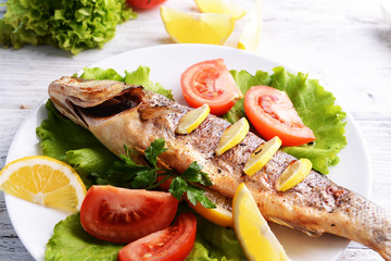 Tasty baked fish on table close-up