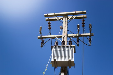 electrical post with power line cables on blue sky