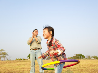 happy little girl playing hula hoops outdoors