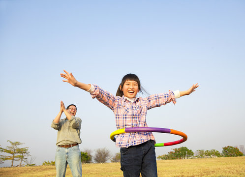 happy kid playing  hula hoops outdoors