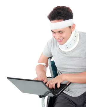 injured young man in wheelchair work on laptop
