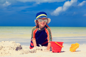 little boy digging sand on tropical beach © nadezhda1906