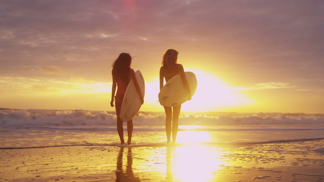 Young Female Surfing Friends Ocean Shallows Sunset Together 