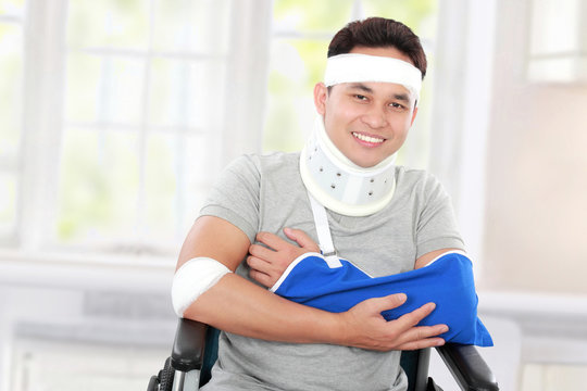 injured young man in wheelchair with cross arm