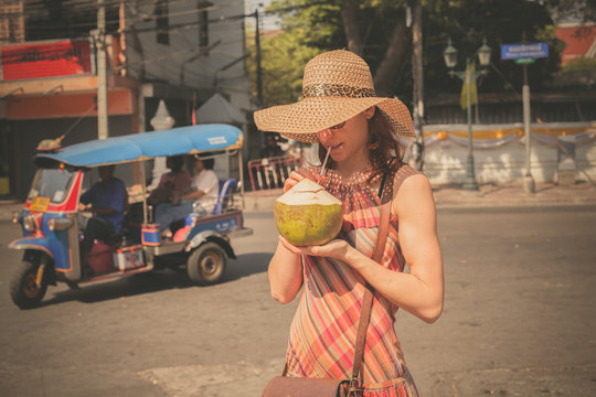 Woman drinking from coconut in the street
