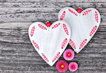 Two hearts with flowers on a wooden background old