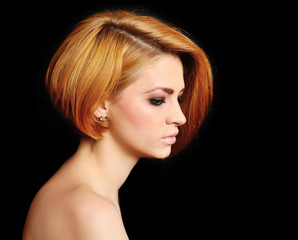 Red hair. Beautiful Woman with Short Hair on a black background.