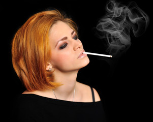 Obraz premium Portrait of beautiful redheaded girl with cigarette