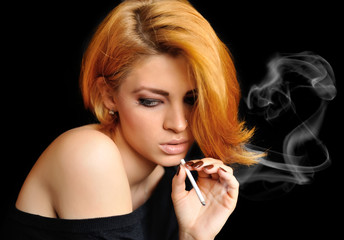 Obraz premium Portrait of beautiful redheaded girl that smokes