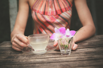 Young woman drinking tea at table