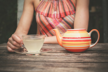 Young woman drinking tea at table